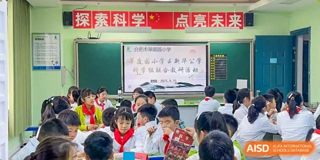 Students in a bright classroom engaging with a presentation on the screen during a school event or lecture, Hefei Xinhua Academy.