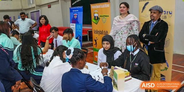 Students and teachers from Pakistan Embassy College Beijing participating in an indoor activity at a school event.