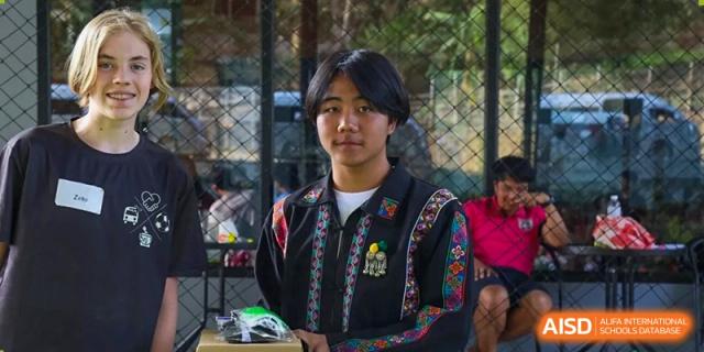 A portrait of a student wearing a jacket with traditional decorative patterns during a cultural celebration at Tianjin International School (TIS).