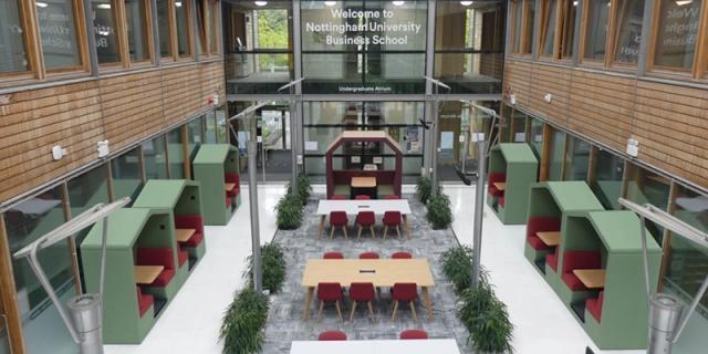 The bright, modern interior common space of the Normanton Community Business School is visible, designed with seating and tables for student study and collaboration at Maple Leaf International School Shanghai.