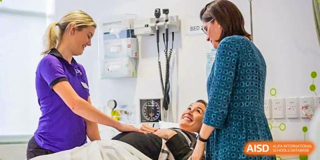 A patient is examined on a bed while two female nurses or doctors discuss her health status in the bright, well-equipped clinic at Maple Leaf International School Shanghai.