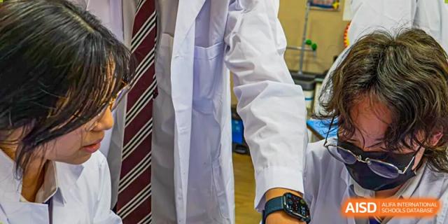 A close-up of a student in a lab coat and school tie, highlighting focus on science and formal studies at Living Word Shanghai.