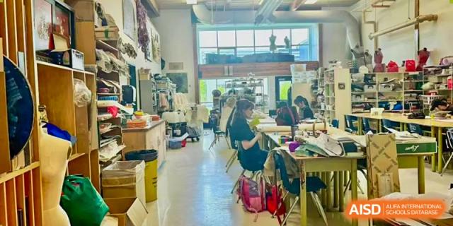 Students working in a brightly lit, open workshop environment, collaborating on various creative projects at Living Word Shanghai.