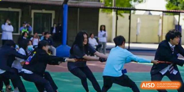 Students participate in an intense tug-of-war competition during a sports day event, demonstrating teamwork and school spirit at Living Word Shanghai.