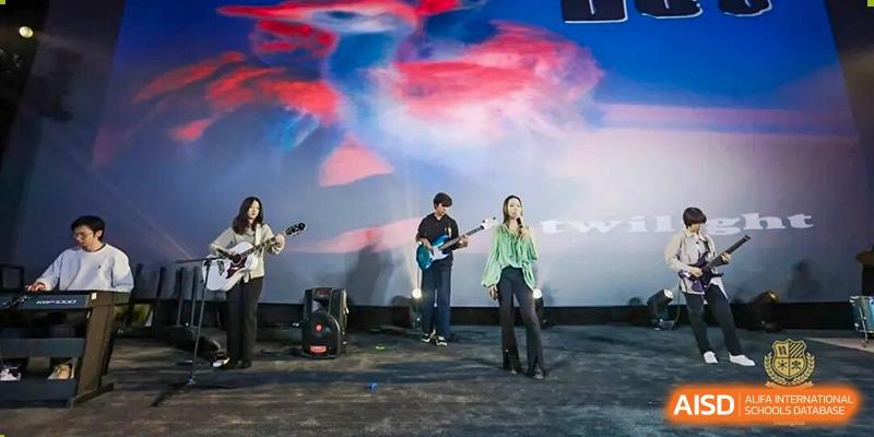 A student band performing live on stage at a school event, playing electric guitars and other instruments under vibrant, artistic lighting, Living Word Shanghai.