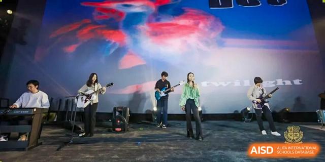 A student band performing live on stage at a school event, playing electric guitars and other instruments under vibrant, artistic lighting, Living Word Shanghai.