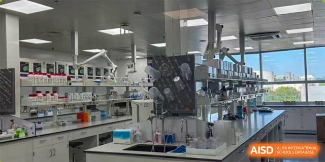 A view inside a high-tech science laboratory with various equipment, including a screen displaying brain scans or complex data at Jian Ping High School.