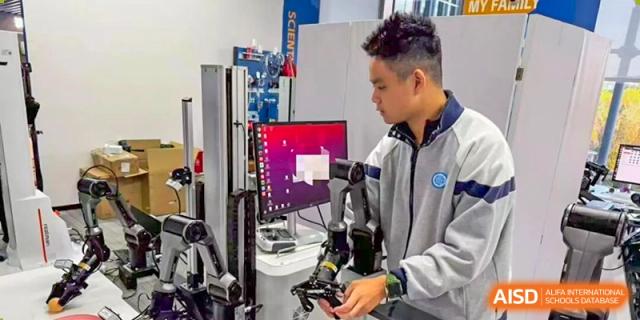 Two male students collaborate, looking at a computer screen and specialized equipment in a technology-focused lab at Jian Ping High School.
