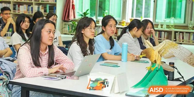 Students collaborate on a project using laptops in a bright, modern learning space at International Studies Center Of Chongqing Nankai Secondary School.