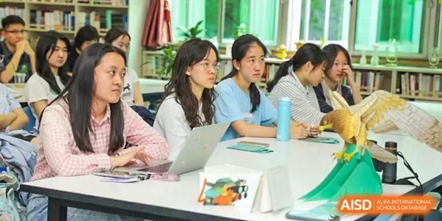 Students collaborate on a project using laptops in a bright, modern learning space at International Studies Center Of Chongqing Nankai Secondary School.