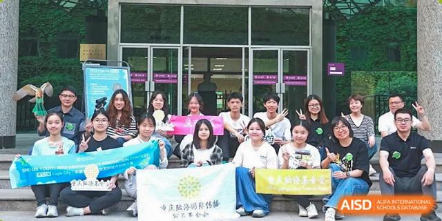 A large group of students in casual attire poses together for a commemorative photo at International Studies Center Of Chongqing Nankai Secondary School.
