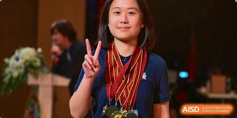 A female student smiles proudly while wearing multiple gold medals around her neck at International Studies Center Of Chongqing Nankai Secondary School.