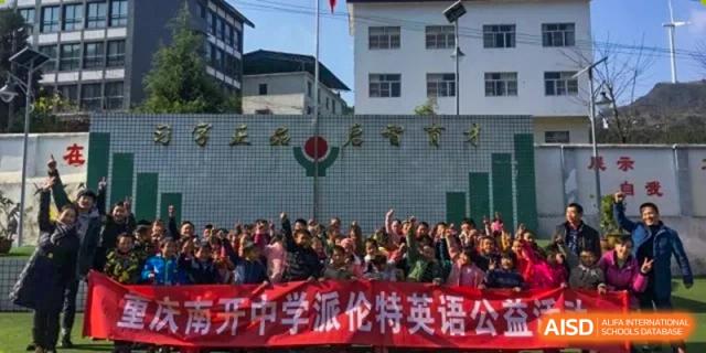 A large crowd of students and teachers gathers in front of a red school banner at International Studies Center Of Chongqing Nankai Secondary School.