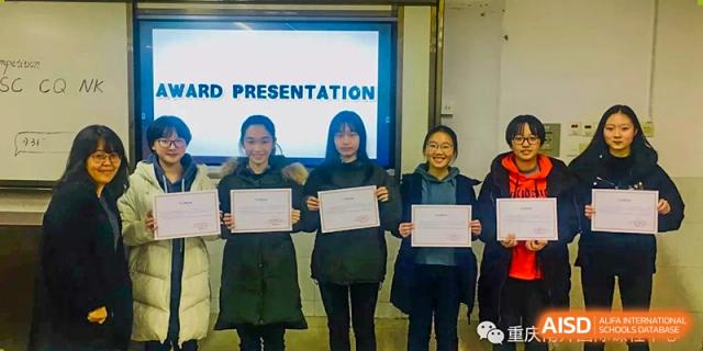 Three students stand in front of a digital screen holding certificates of achievement at International Studies Center Of Chongqing Nankai Secondary School.