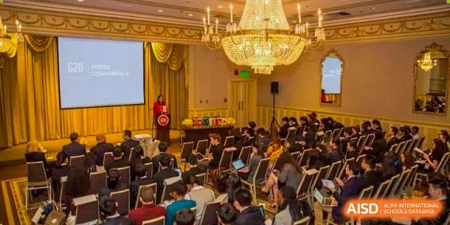 A large group of students listens to a lecture in a grand, chandelier-lit auditorium at International Studies Center Of Chongqing Nankai Secondary School.