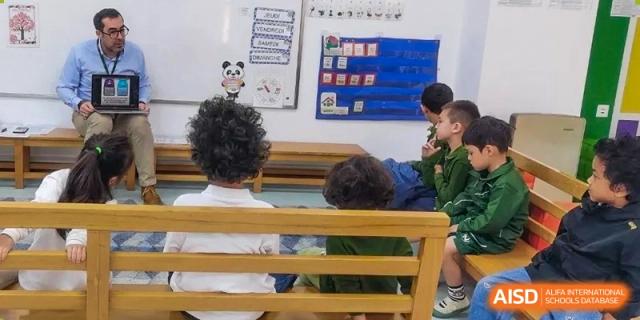 Students sitting on wooden benches and focusing on a whiteboard featuring a panda illustration and French vocabulary at Ecole Française Internationale de Wuhan.