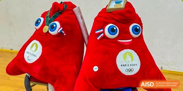 A close-up of the red Phryge mascot representing the Paris 2024 Olympic Games on display at Ecole Française Internationale de Wuhan.