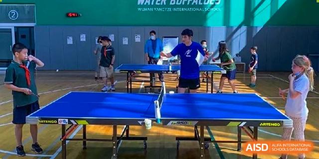 Students participating in a competitive table tennis match during a sports event or PE class at Ecole Française Internationale de Wuhan.