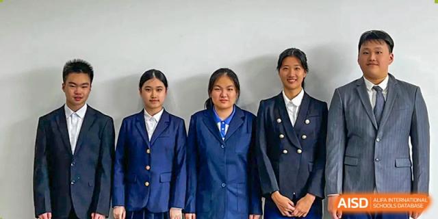 Three female students posing side-by-side in formal navy blue blazers with gold buttons at Shenzhen Senior High School International Division.