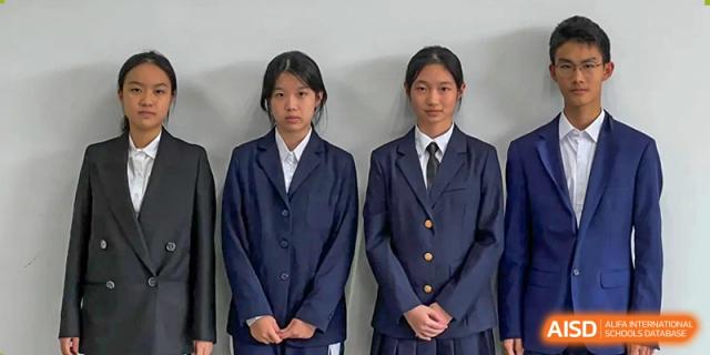Two female students standing side-by-side wearing formal navy blue blazer uniforms and white collared shirts at Shenzhen Senior High School International Division.
