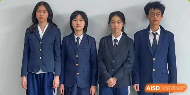 Two female students posing in formal navy blue school blazers with gold buttons and matching ties at Shenzhen Senior High School International Division.