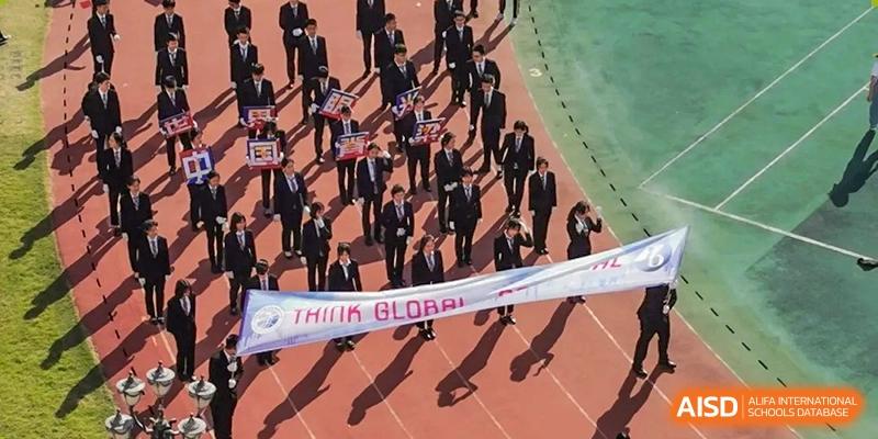 An overhead view of students in suits marching on a red track while carrying a "Think Global" banner at Shenzhen Senior High School International Division.