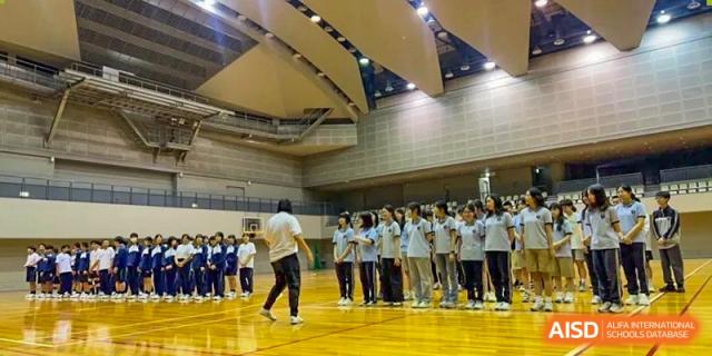 A wide shot of students in a large gymnasium lined up for a sports activity at Wuxi Foreign Language School International Curriculum Center.