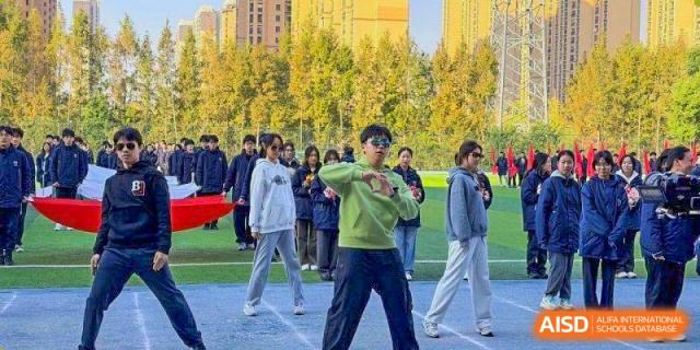 Students in casual athletic wear perform a synchronized dance on a field at Wuxi Foreign Language School International Curriculum Center.