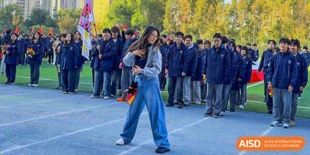 A student in a grey hoodie and wide-leg jeans performs a dance routine at Wuxi Foreign Language School International Curriculum Center.