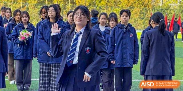 A female student in a formal navy blue school blazer and striped tie at Wuxi Foreign Language School International Curriculum Center.