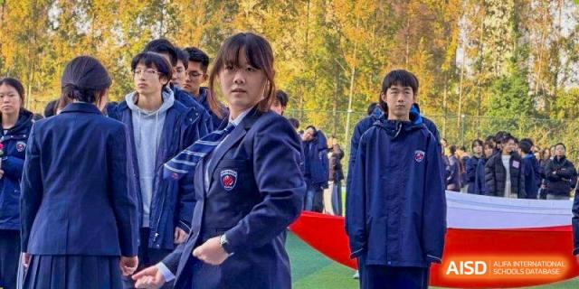 A student wearing a formal school uniform blazer looks off-camera during an event at Wuxi Foreign Language School International Curriculum Center.