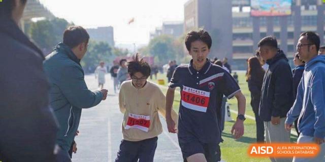 Two students sprint toward the finish line during a competitive outdoor race at Wuxi Foreign Language School International Curriculum Center.