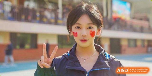 A student with heart stickers on her cheeks smiles for a portrait at Wuxi Foreign Language School International Curriculum Center.