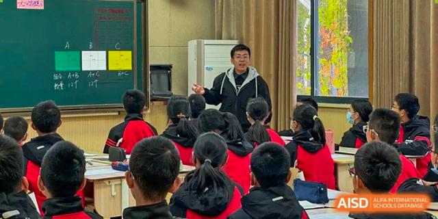 A teacher stands at the front of the room delivering a presentation to a focused class at Wenzhou Foreign Language School.