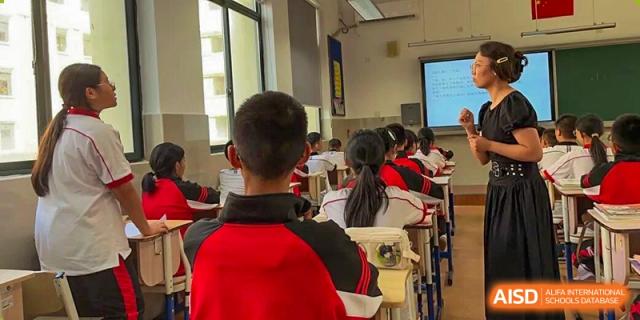 A classroom perspective from the back showing students facing a whiteboard during a lesson at Wenzhou Foreign Language School.