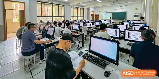 Students working on desktop computers in a bright, modern computer lab facility at Wenzhou Foreign Language School.