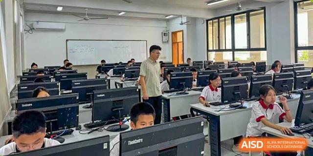 An instructor monitors students as they work on individual computer stations in a lab at Wenzhou Foreign Language School.