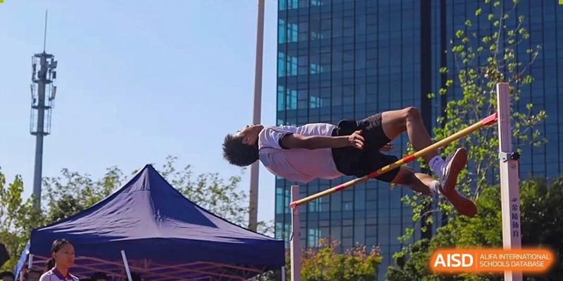 A student athlete performing a high jump over a bar during a track and field competition at Wenzhou Foreign Language School.