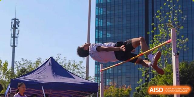 A student athlete performing a high jump over a bar during a track and field competition at Wenzhou Foreign Language School.