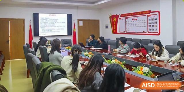 A group of students and faculty participating in a formal meeting or presentation inside a conference room at Wenzhou Foreign Language School.