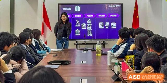 A female presenter stands by a large monitor during a professional development seminar or student meeting at XuZhou No.3 Middle School.