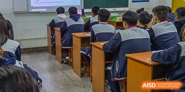 A group of students in matching tracksuits sits in a classroom during a focused study session at XuZhou No.3 Middle School.