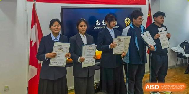Four students stand in a row holding award certificates after an academic competition or ceremony at XuZhou No.3 Middle School.
