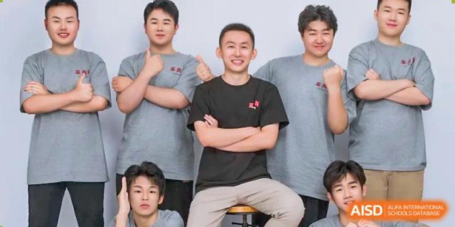 Four male students in casual grey and black shirts smile together for a friendly group portrait at XuZhou No.3 Middle School.