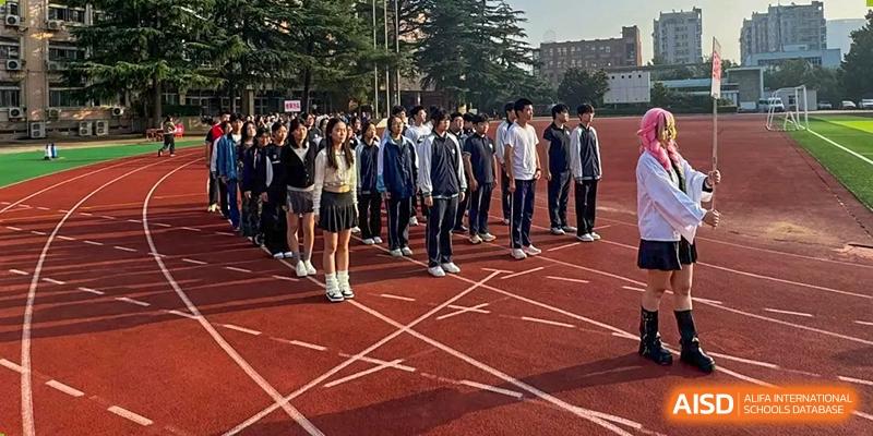 Students stand in organized rows on an outdoor running track during a formal school assembly or athletic event at XuZhou No.3 Middle School.