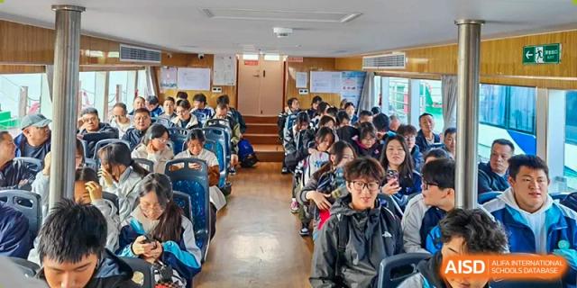 Students sit together inside a tour bus while traveling to an educational destination during a school trip at XuZhou No.3 Middle School.