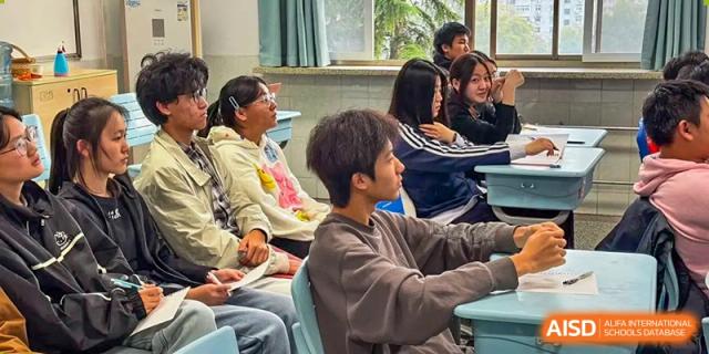 A group of students sits attentively in their classroom during a lesson, looking toward the front of the room at XuZhou No.3 Middle School.