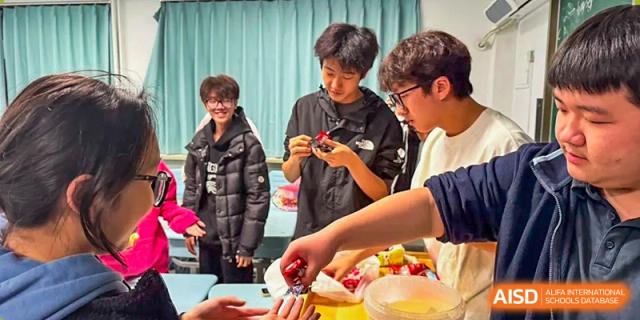 A group of students gathers around a table to collaborate on a hands-on project during a creative workshop at XuZhou No.3 Middle School.