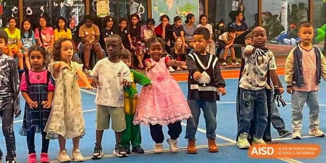 Students in formal and costume attire perform a synchronized routine on an indoor blue court for an event at École Française Internationale de Canton(EFIC)