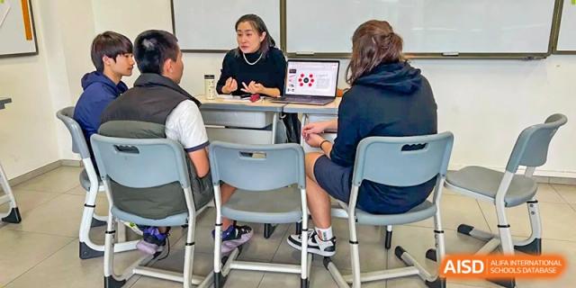Two students work together on a laptop at a desk during a technology-focused classroom activity at École Française Internationale de Canton(EFIC)